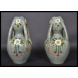 A pair of early 20th century Art Nouveau ceramic four handled vases having painted floral sprays and