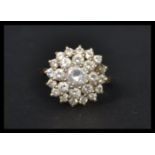 A hallmarked 9ct gold CZ cluster ring having a central white stone with a two layer cluster of