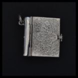 A sterling silver pendant in the form of a novelty miniature book. Weighs 15 grams.