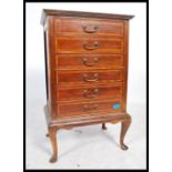 An Edwardian mahogany inlaid pedestal music cabinet being raised on cabriole legs with upright