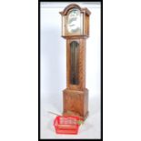 A 20th century oak cased Tempus Fugit longcase clock. The silvered dial with brass spandrels and