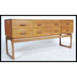 A 1970's retro G-Plan Quadrille pattern teak wood sideboard chest raised on squared legs with a