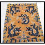 An early 20th century Tibetan dragon rug.  The orange ground with 5 dragons chasing flaming pearls