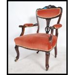 A 19th century Victorian inlaid and carved elbow mahogany salon arm chair raised on turned legs on