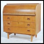 A 1960's retro teak wood roll top  cylinder bureau having three drawers with inset handles raised on