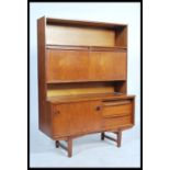 A retro 1960's teak wood highboard unit comprising of twin floating drop down cupboards raised above