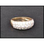 A hallmarked 9ct gold and CZ ring having ribbed shoulders and pave set CZ. Hallmarked Sheffield.