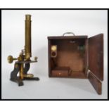 A late 19th century lacquered and painted brass monocular microscope, with eyepieces and slides,
