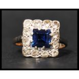 A 9ct gold sapphire and white stone rig set with a square cut blue sapphire surrounded by a halo