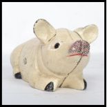 A vintage 20th century cast iron novelty money box in the form of a pig. Modelled in a seated