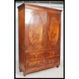 A late Victorian flame mahogany double wardrobe being raised on turned legs with oval panel doors