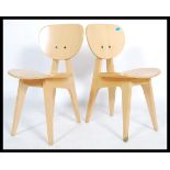 A pair of 20th century retro vintage steamed ply chairs raised on angular legs. Measures 79cm x 42cm