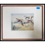 A 20th century handpainted lithograph print of flying mallards  and duck being signed by the