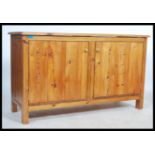 A contemporary 20th century pine dresser base cupboard. Of plain panel form with double doors having