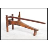A late 19th century antique oriental fruit press having a pivoting lever and wedge to crush the