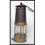 An early 20th century cast metal and brass miners lamp having a hook atop. Measures 26 cm high