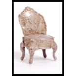 A silver hallmarked silver Dolls house chair in the form of a 19th Century French Louis XV style