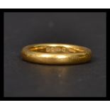 A ladies small hallmarked 22 ct gold band ring of usual form, With a Birmingham hallmark, date