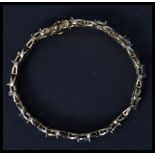 A 925 gilded silver sapphire adorned ladies tennis bracelet. The bracelet with 12 sapphires having