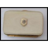 A vintage 19th century ivory and gilt metal purse with monogrammed armorial crest to front push