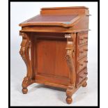 A Victorian style mahogany davenport writing desk. The gilt tooled leather desk top having appointed