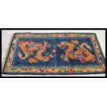 An early 20th century Tibetan double dragon rug. The blue ground with 2 dragons surrounded by