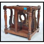 A Victorian walnut 19th century canterbury - magazine rack having pierced uprights with  plinth base