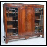 An early 20th century mahogany display cabinet bookcase, central panel cupboard door flanked by