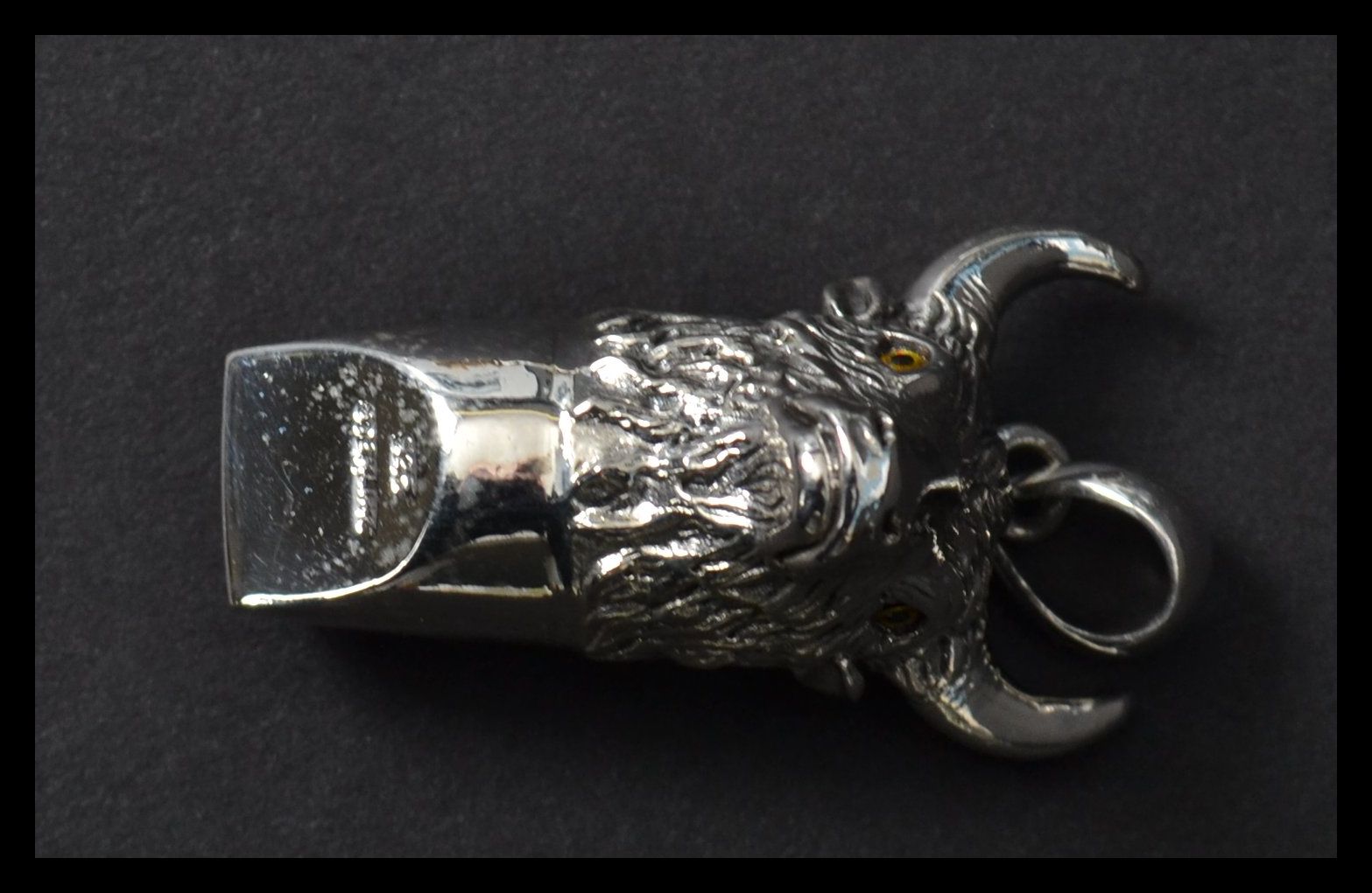 A sterling silver whistle in the form of  a bulls head with horns and bail loop. Weighs 17 grams.