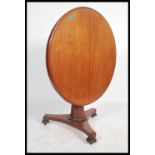 A Victorian mahogany tilt top loo table having a faceted octagonal tapering column supported by a