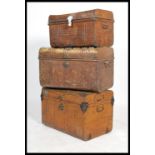 A group of three vintage 20th century industrial luggage tin trunks having folding handles to