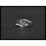 A 14ct white gold sapphire and diamond cross over ring of knot form. Weighs 3.9 grams size O.