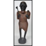 A 20th century large African Tribal carving figurine of a warrior holding an axe and club raised