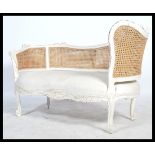 A good 20th century French window seat / loving sofa having bergere caned upright back rest, white
