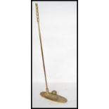 A 20th century brass golfing trophy door stop in the form of a golf ball and club. Measures 63 cm