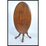 A Victorian 19th century mahogany oval tilt top breakfast / loo table being raised on cabriole leg