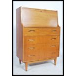 A retro 20th century teak wood bureau having a fall front with fully appointed interior over a