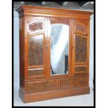 A good Edwardian walnut triple / large double wardrobe having a deep plinth drawer base with upright