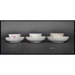 A group of three 18th century English famille rose tea bowls and saucers painted with pink ribbon