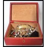 A vintage red leather and gilt tooled jewellery box opening to reveal a collection of vintage