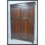 A 1920's oak bachelors compactum wardrobe. Raised on bracket feet with twin panel doors having a