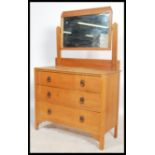 A 1920's light oak dressing chest of drawers. The chest with short and deep drawers having swing