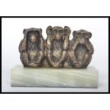A vintage wise monkey 'see no evil, hear no evil, speak no evil' silver plated figurine group raised