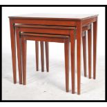 A retro vintage 1970's teak wood trio nest of tables having rectangular tops raised on square