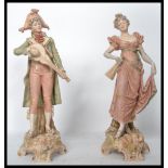 A pair of Royal Dux ceramic figures modelled as a lady and gent. Pink Royal Dux triangles to base.
