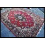 An early 20th century decorative Persian carpet rug having a red ground with geometric pattern.