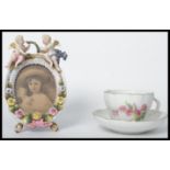 A 19th century Meissen porcelain hand painted cup and saucer along with a Sitzendorf cherub