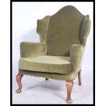 A mid 20th century Antique revival  Parker Knoll wingback armchair raised on cabriole legs with