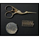 A silver miniature abacus pendant along with a pair of crane bird vanity scissors and a St