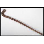 A 19th century bamboo walking stick cane. The handle carved as a dog eating a bird. Please see